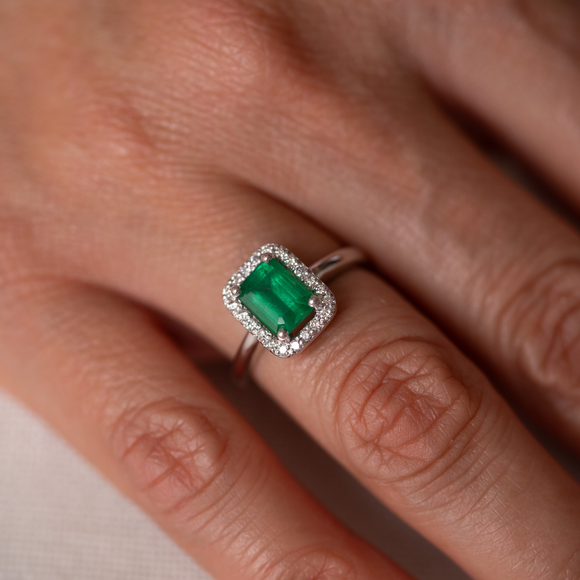 Anillo halo con esmeralda corte esmeralda y diamantes