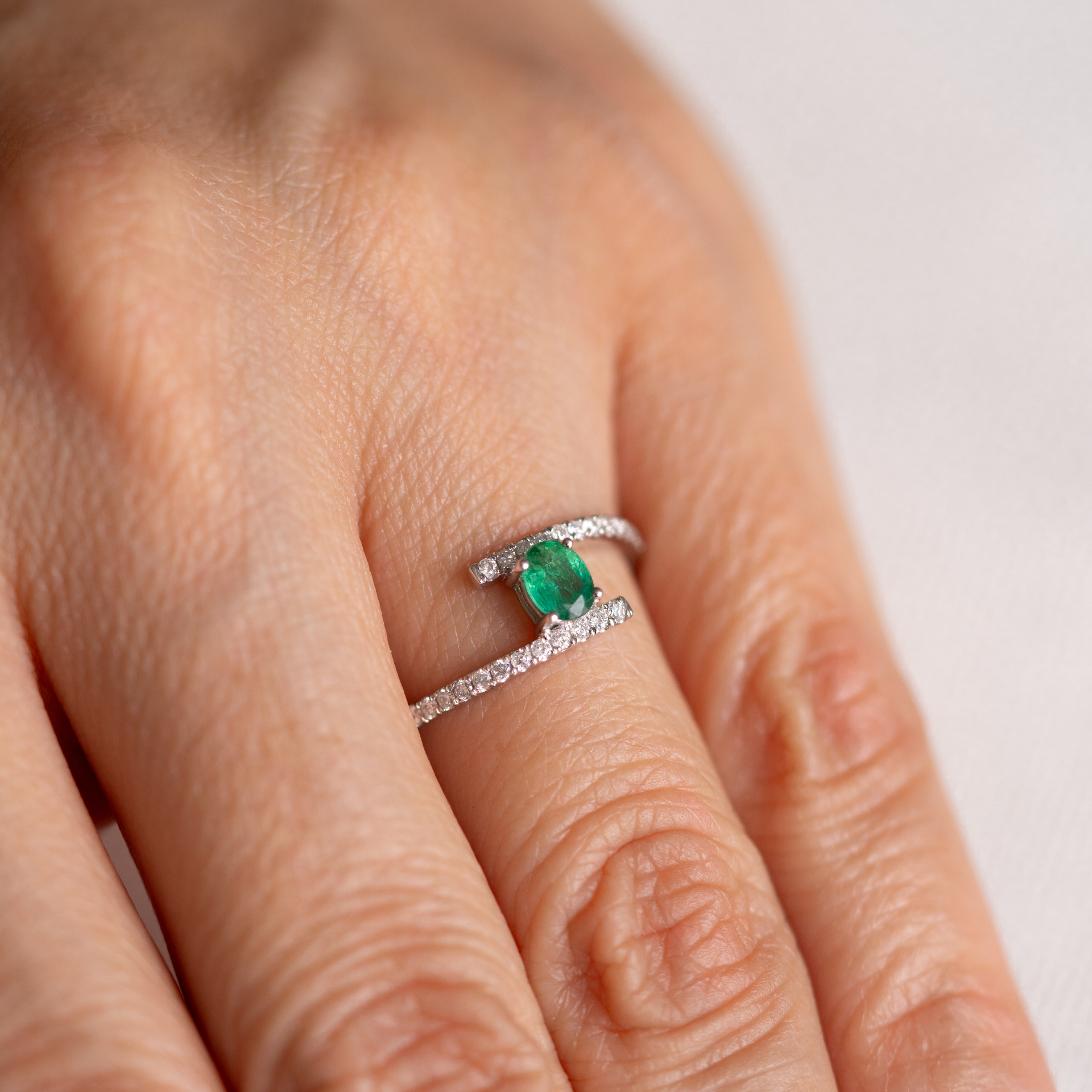 Anillo bypass con esmeralda oval y diamantes
